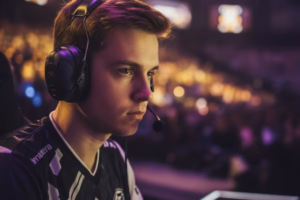 Professional esports player at a tournament stage with headset